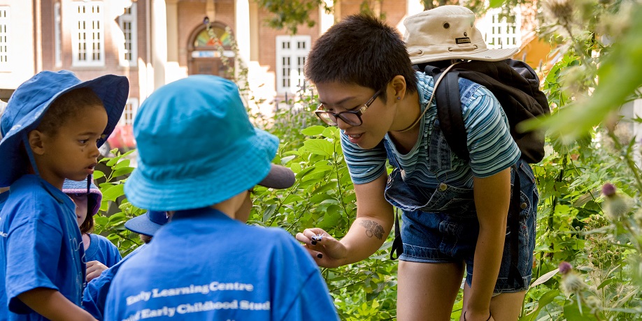 Educator addresses a group of young children outside the Early Learning Centre