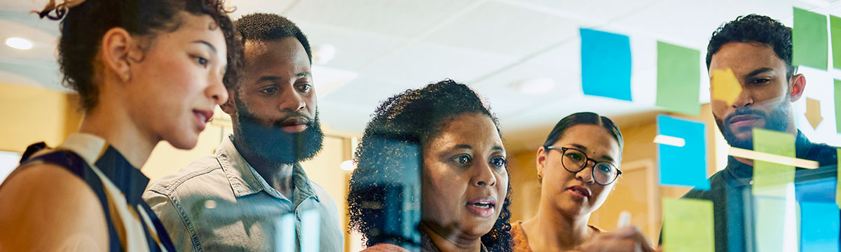 Five people planning using sticky notes for a project