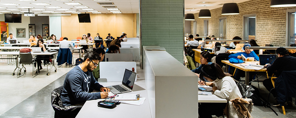 Students study at communal desks in an open work space on the Ryerson campus.
