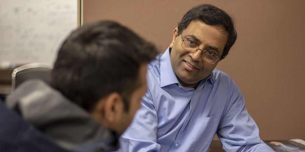 Engineering professor Alagan Anpalagan chats with a student.