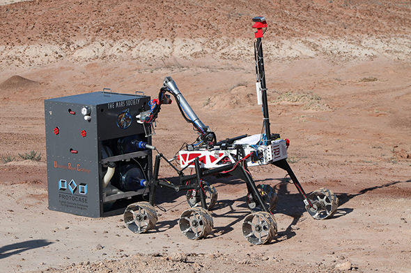 A robotic rover designed by Ryerson Rams Robotics on desert-like terrain.