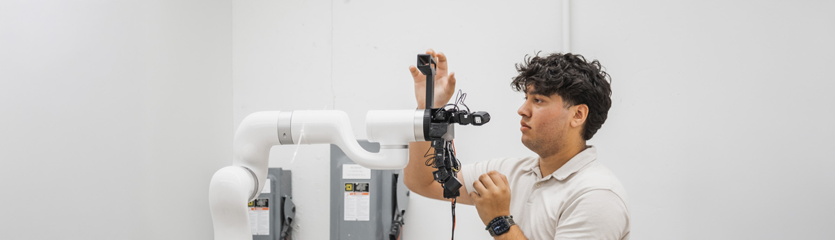 Student in the lab working with robotics equipment.