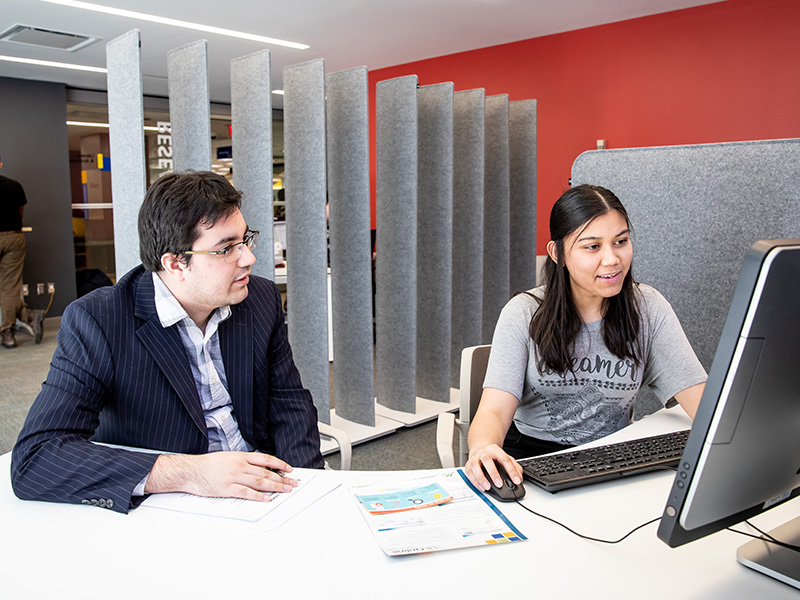 Two colleagues reviewing a computer screen. 
