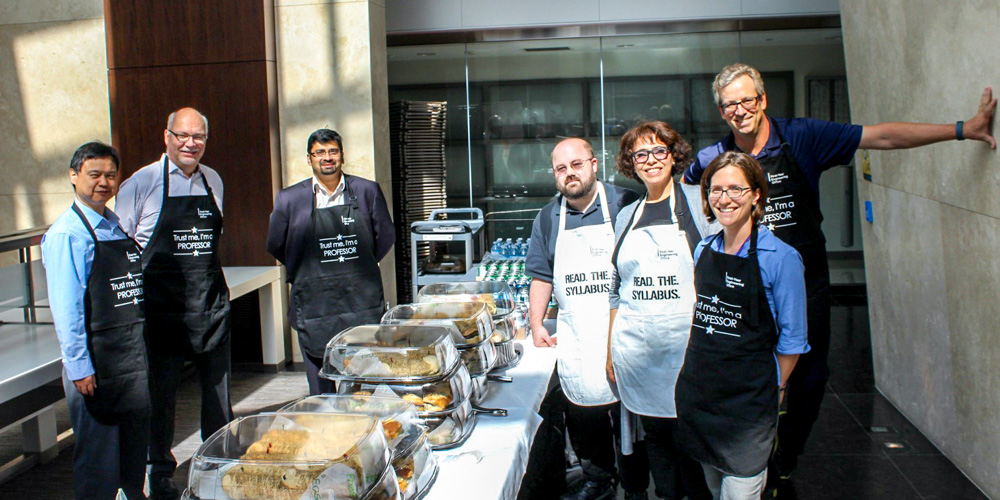 Group of faculty members serving food at an event