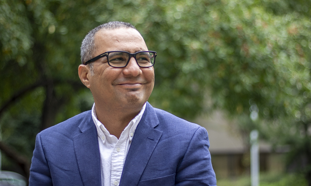 Dr. Bilal Farooq smiles outside in a suit