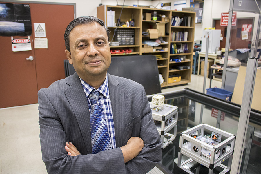 Dr. Krishna Kumar stands with his arms folded