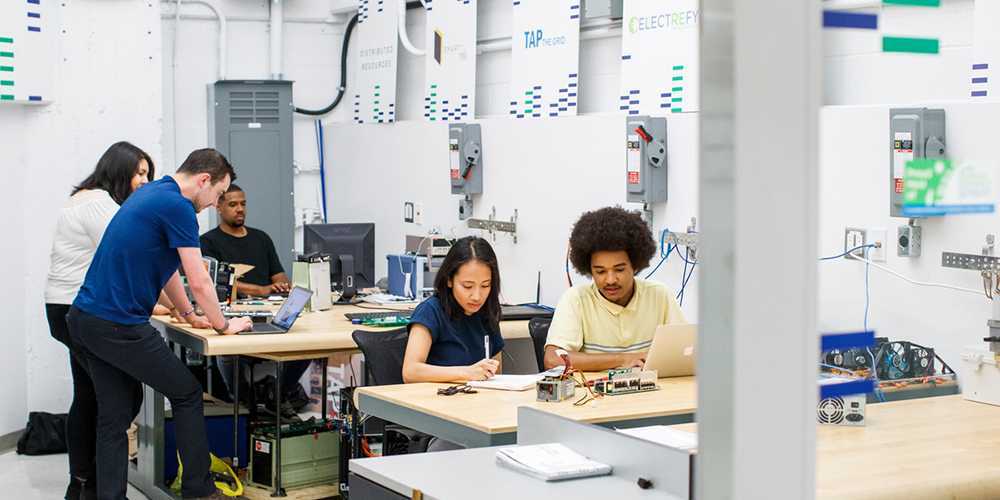 A group of researchers are working together and independently in a collaborative work space