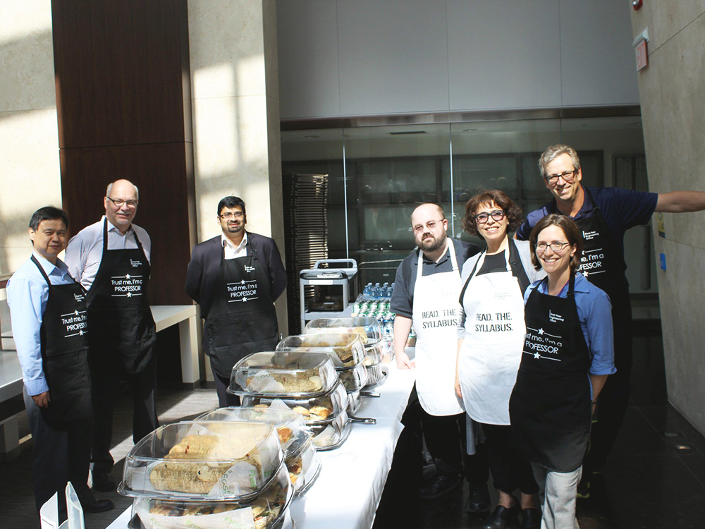 Group of faculty members serving food at an event