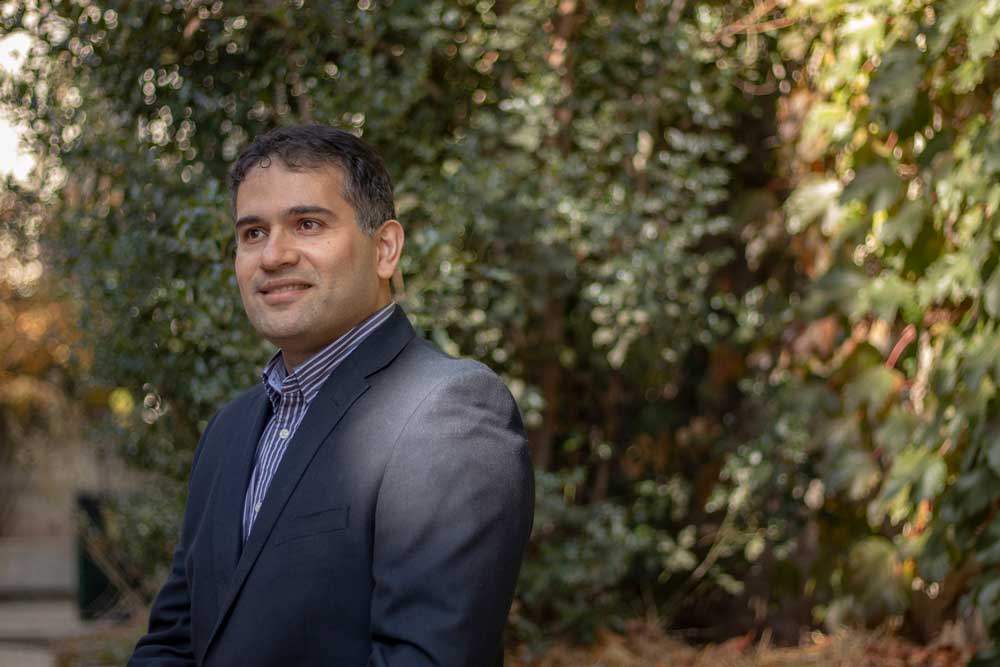 A head shot of Ebrahim Bagheri in front of a hedge
