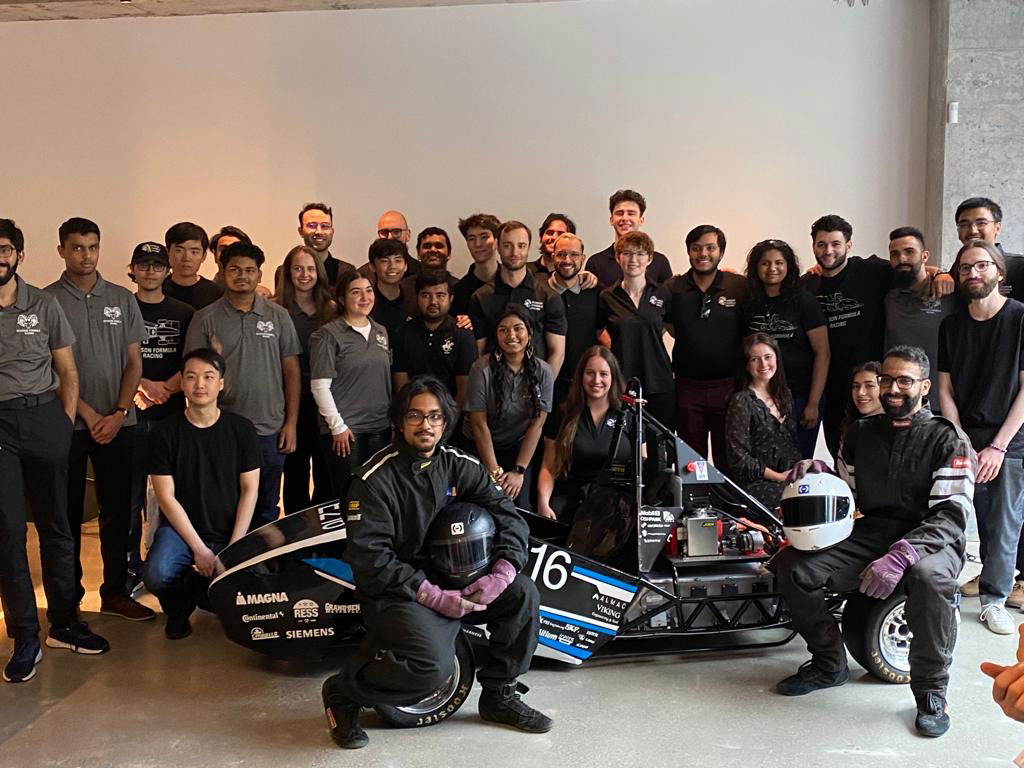 TMU's Formula Racing team poses for a group shot with their E216 electric vehicle
