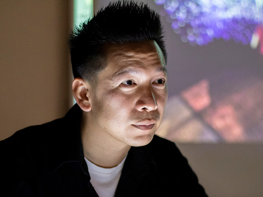 Vincent Hui standing before a projector screen