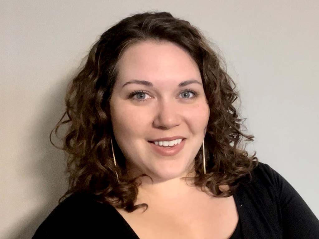 Seanna Thomas (Guillemin) smiles at the camera wearing a black top