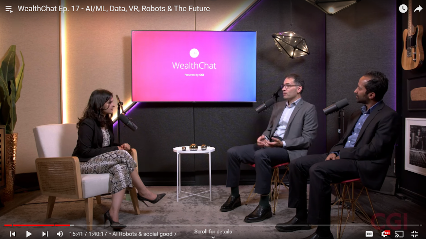 A still from a "WealthChat" video podcast featuring three people in a studio setting. A woman in a black jacket and snakeskin pants is seated on the left, while two men in suits are seated on the right. They are all facing each other, engaged in conversation. In the background, a large screen displays the "WealthChat" logo. The video's title is "WealthChat Ep. 17 - AI/ML, Data, VR, Robots & The Future."