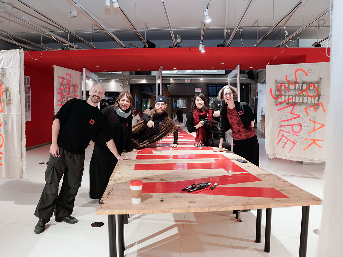  Lisa Landrum standing with smiling group of instructors and students as part of the Radical Hospitality workshop at Toronto Metropolitan University. 
