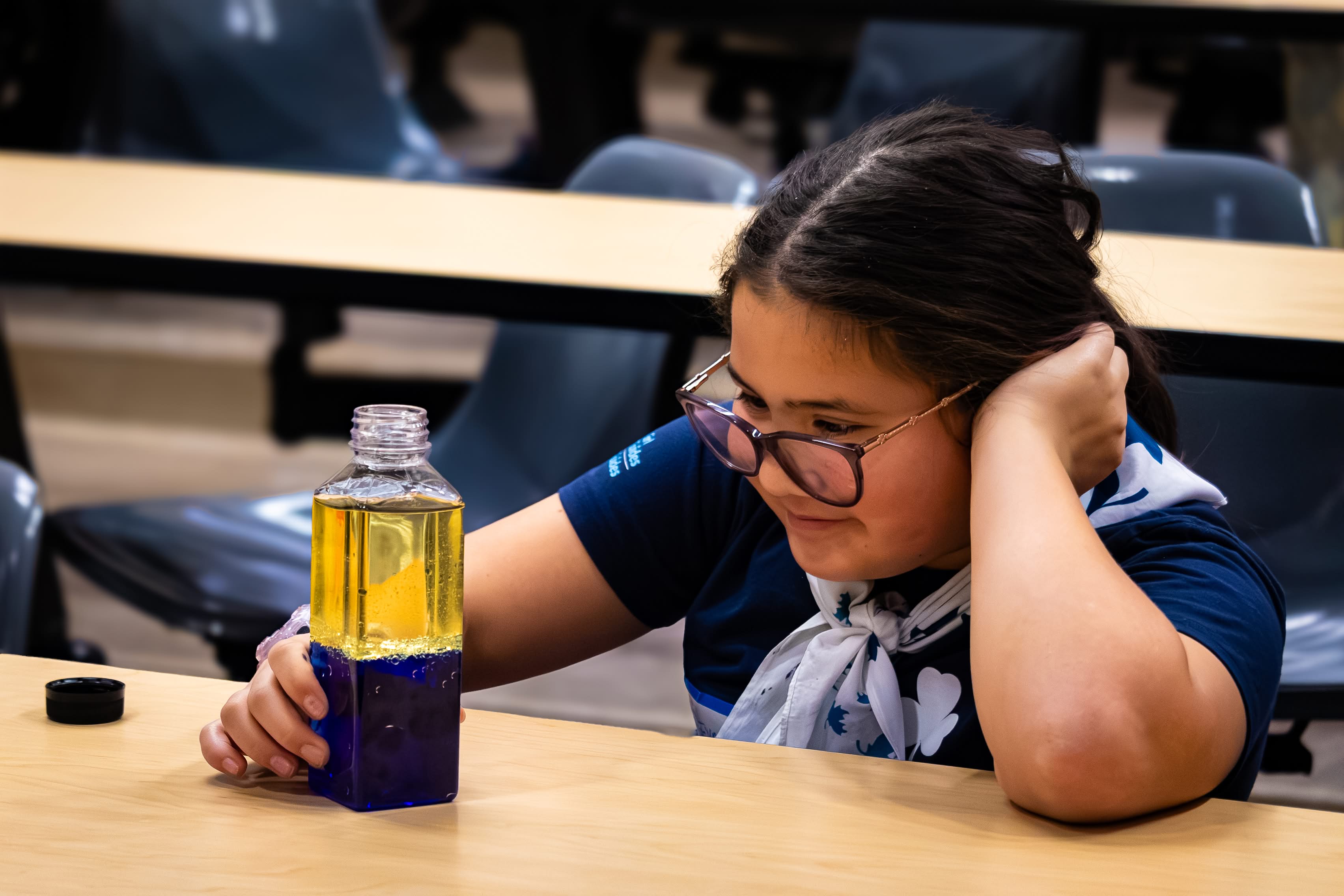 A Girl Guide smiling and watching dark blue lava lamp.