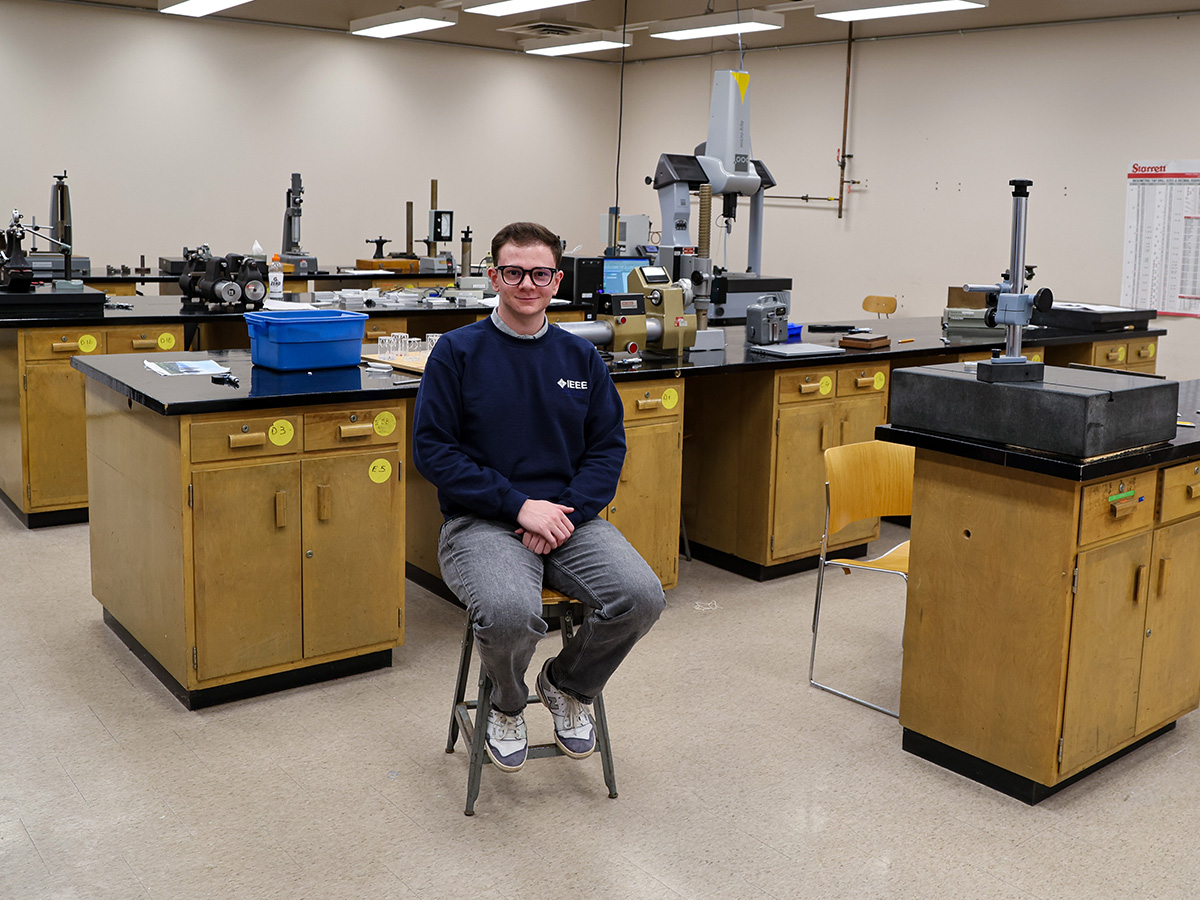 Gianluca Provenzano sitting in an industrial engineering lab at Toronto Metropolitan University.