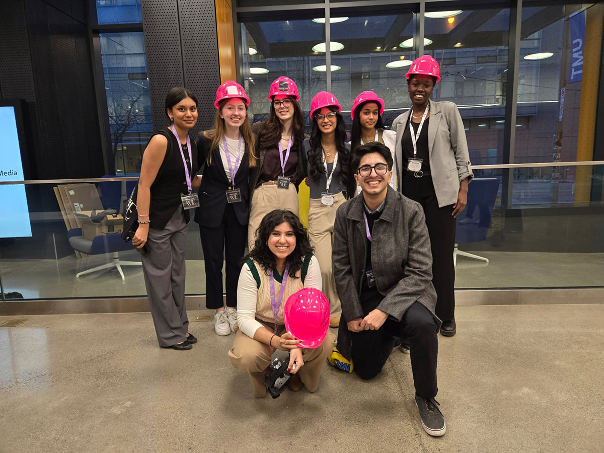 Joella Russell with Women in Engineering executive team members smiling, wearing pink hard hats.