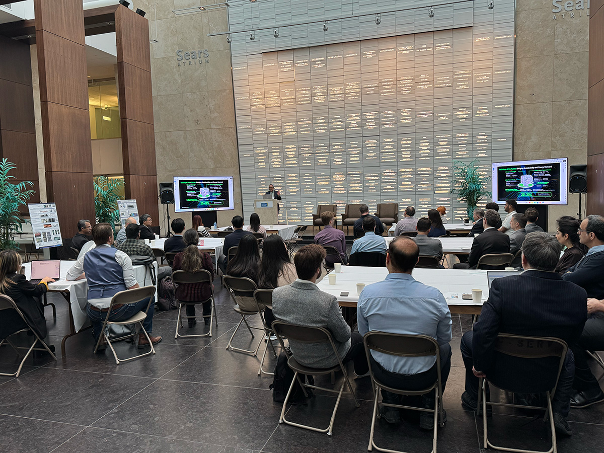 Pratap Revuru presenting to a group of people in an auditorium.