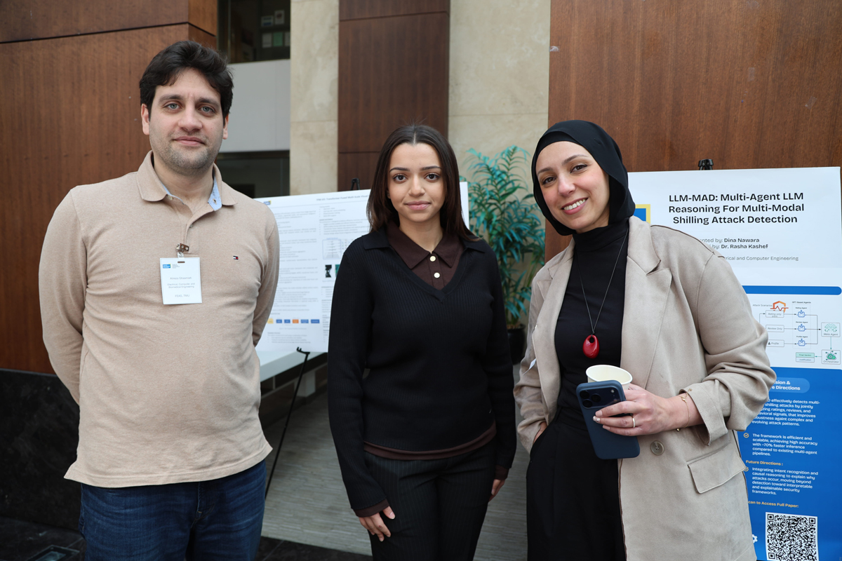 Alireza Ghasmieh standing with two conference participants. 