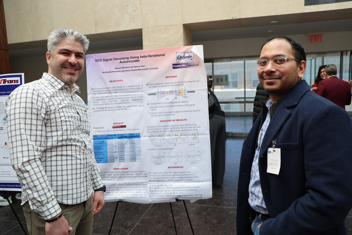 Rollen D’Souza standing next to a research poster. 
