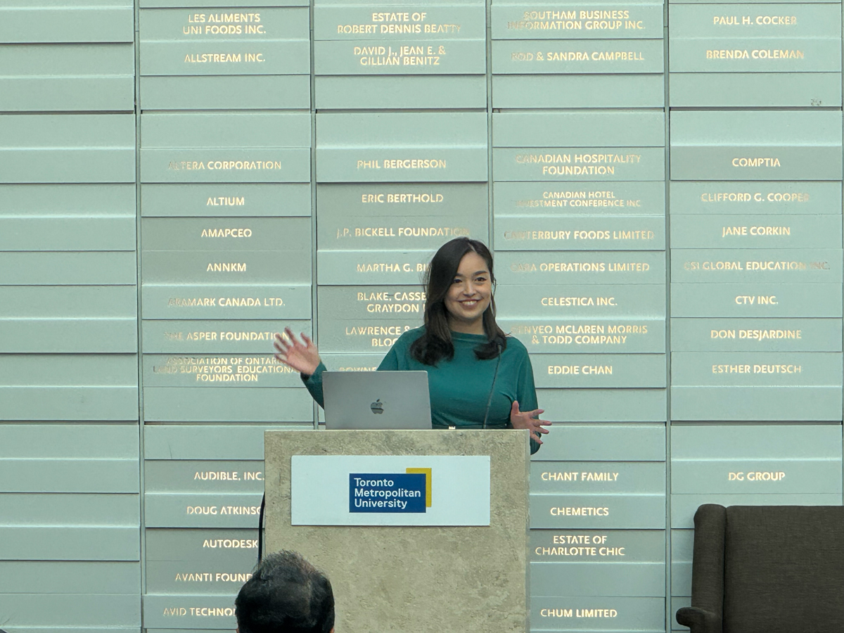 Muxin Ma presenting at podium.