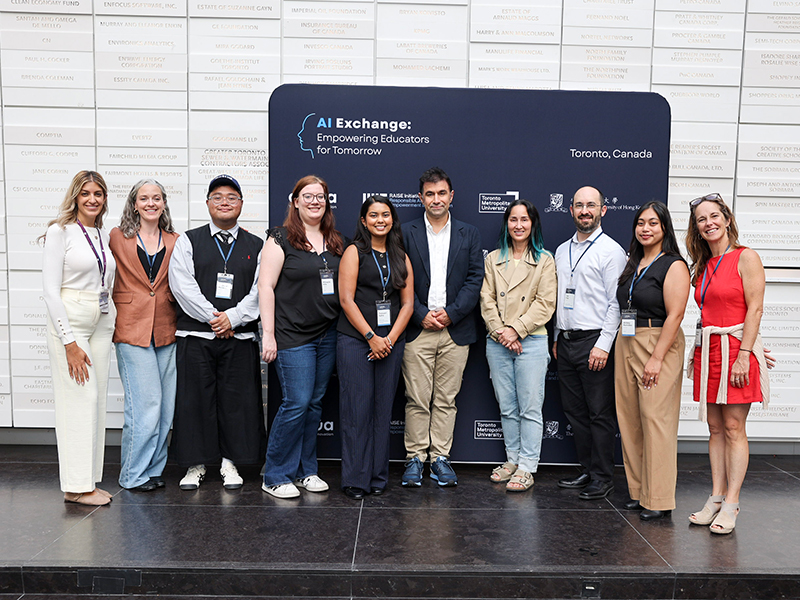 Team members from Toronto Metropolitan University, Actua, and MIT RAISE smiling and standing in front of an AI Exchange Conference banner.