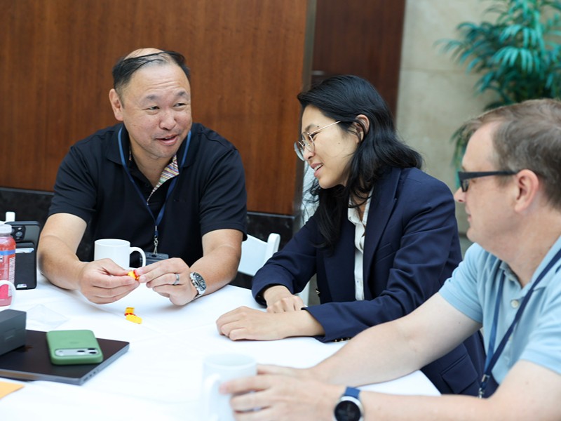 Event attendees gather around a table for a hands-on activity during a breakout session.
