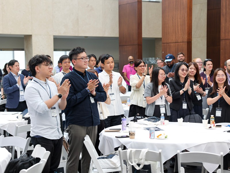 Event attendees stand and applaud at their tables during event wrap-ups.