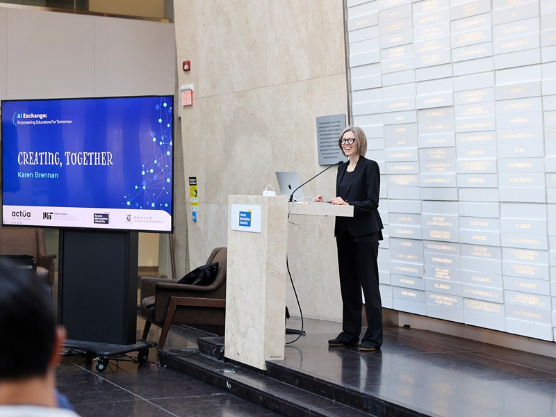 Karen Brennan presents on stage next to a slide titled "Creating, Together".