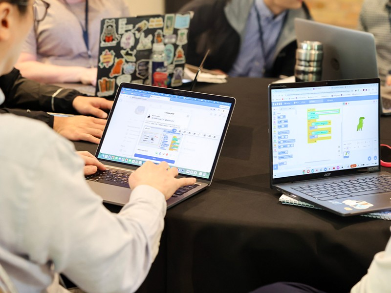 Participants code on laptops during an activity.