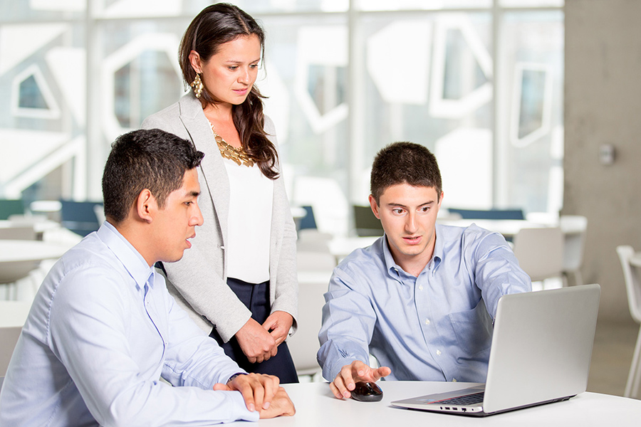 Three student entrepreneurs work on a laptop