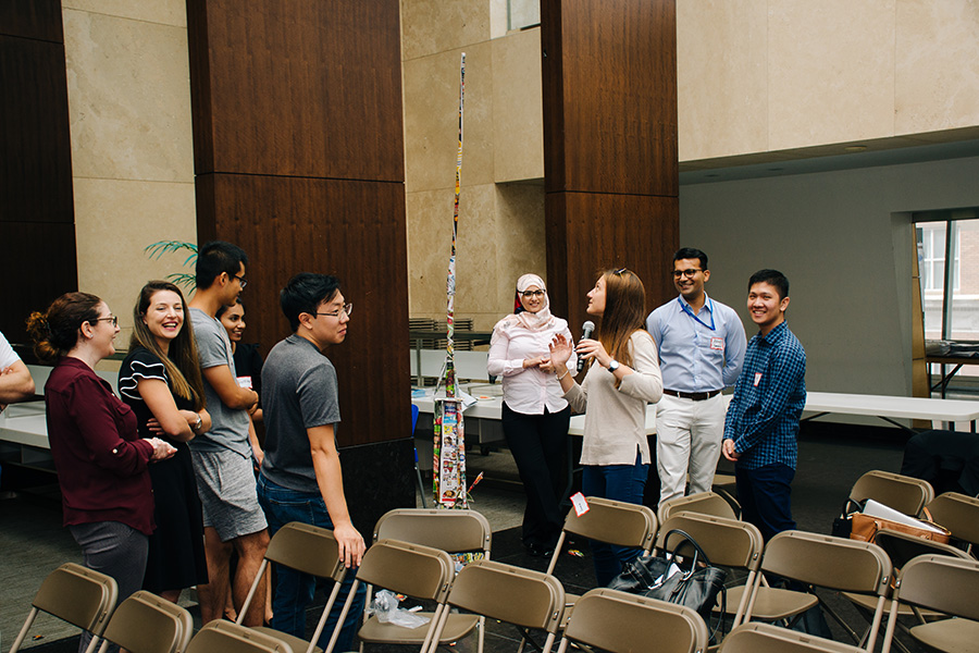 A group of graduate students stand and chat