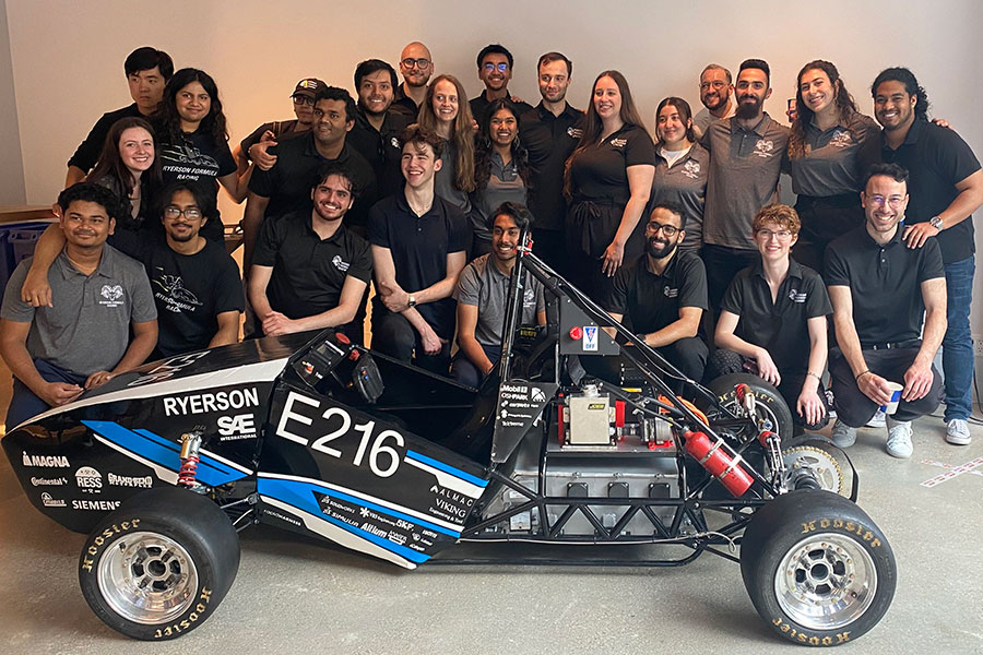 Toronto Metropolitan University Formula Racing team stand behind their E216 electric vehicle