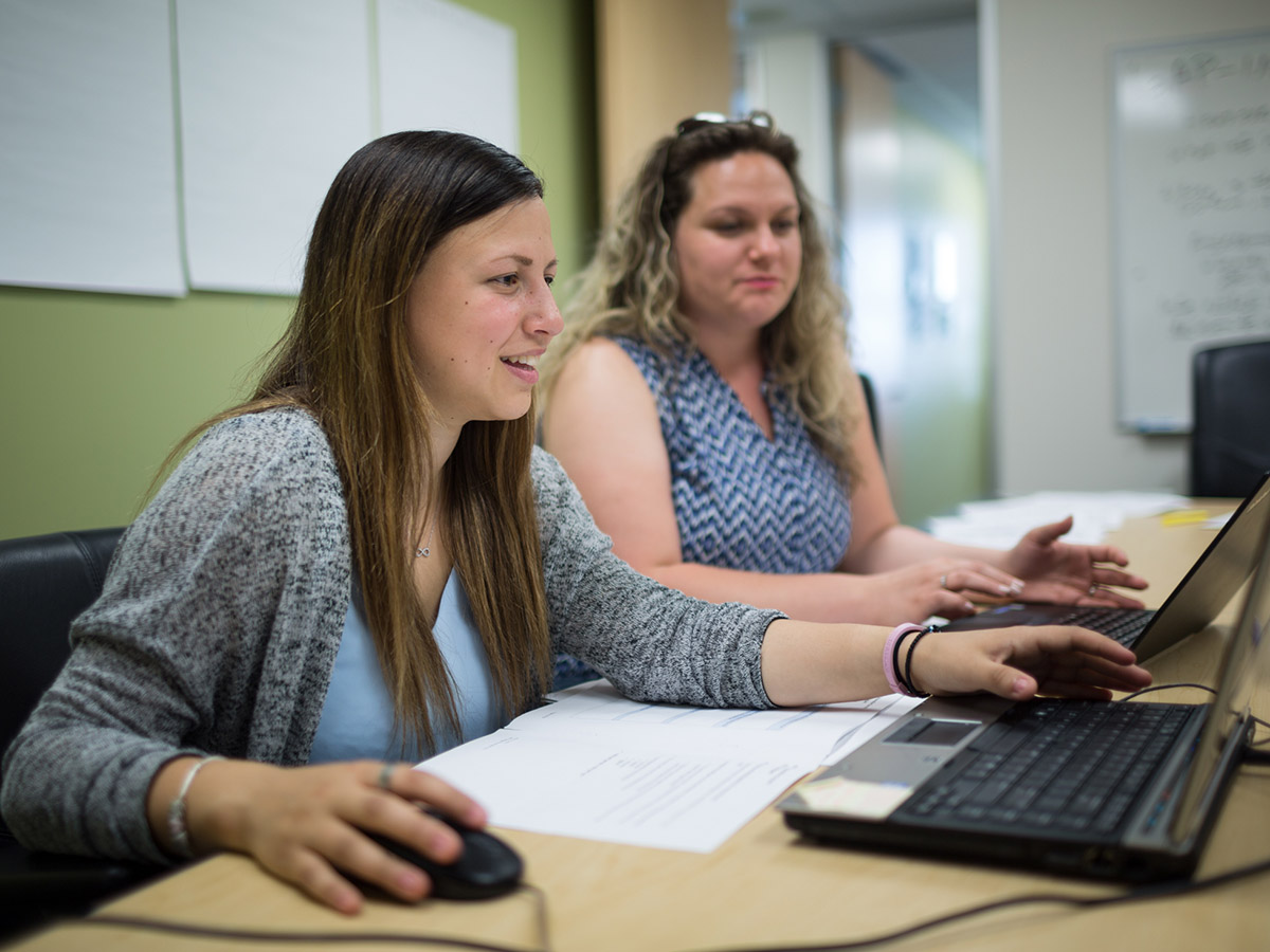 Two undergraduate research assistants sit on a computer