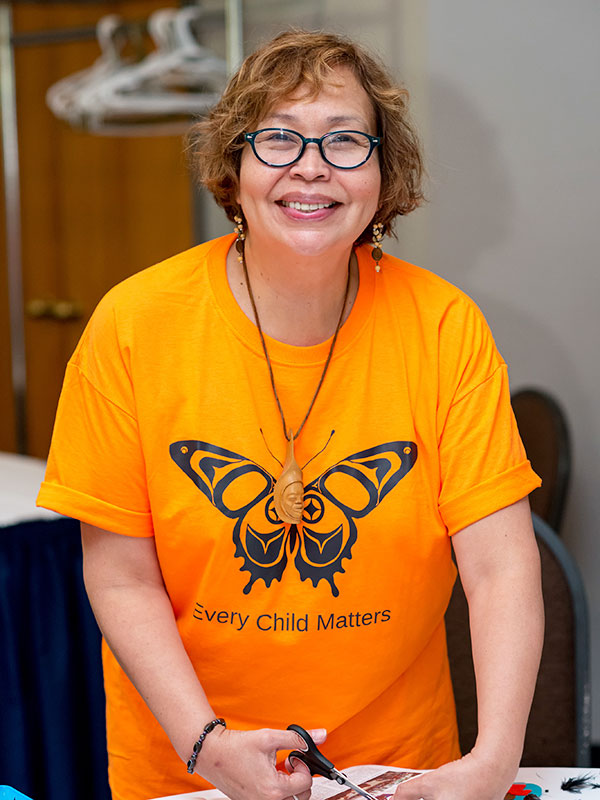 Monica McKay in an orange shirt that reads 