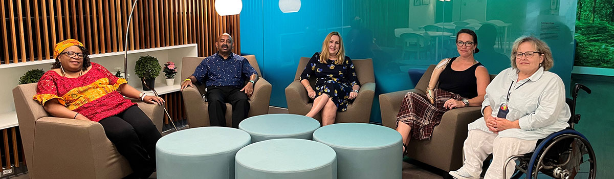 Five people sitting posing for the camera, in the Staff and faculty lounge