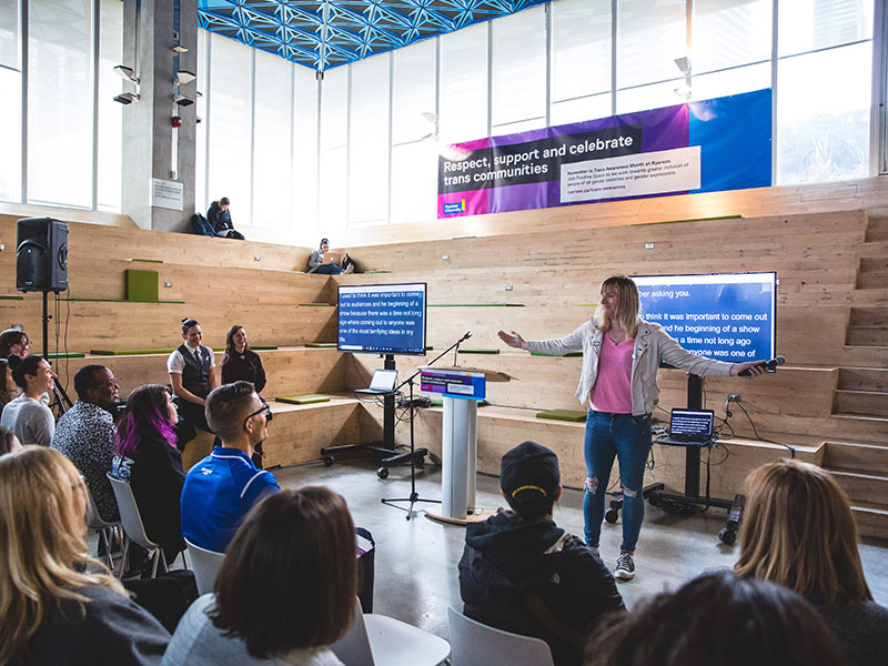 Ashley Cooper (comedian) performs to an audience at the Trans Awareness Month kick-off in 2019 in the Student Learning Centre