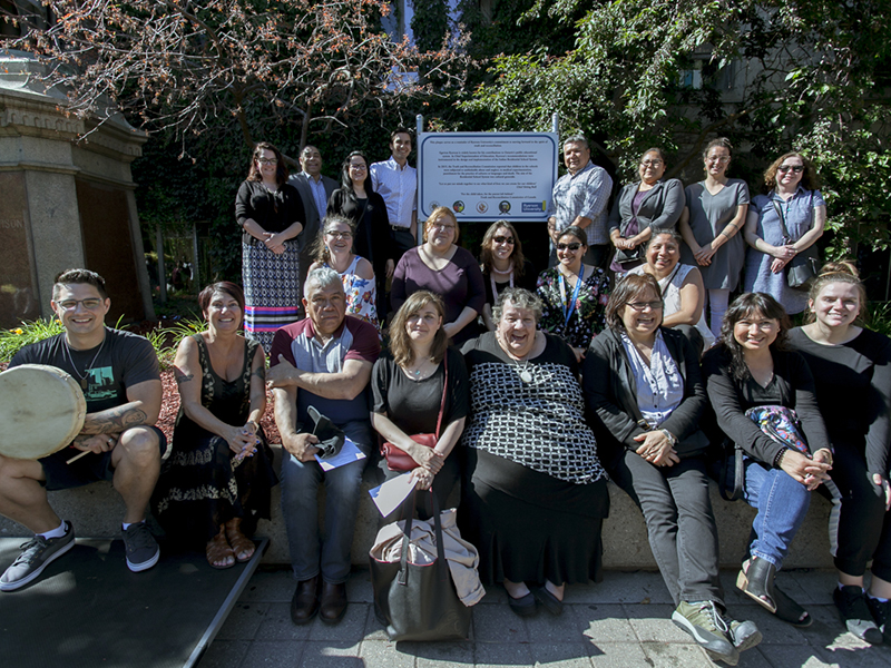 Elder Joanne Dallaire and Indigenous community members standing by the plaque next to the Egerton TMU statue on Gould Street 