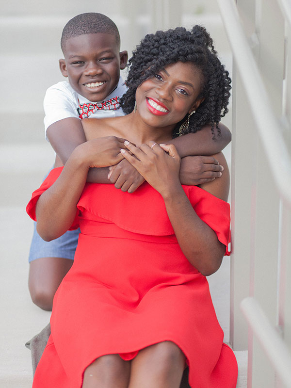 A Black child hugging a Black woman