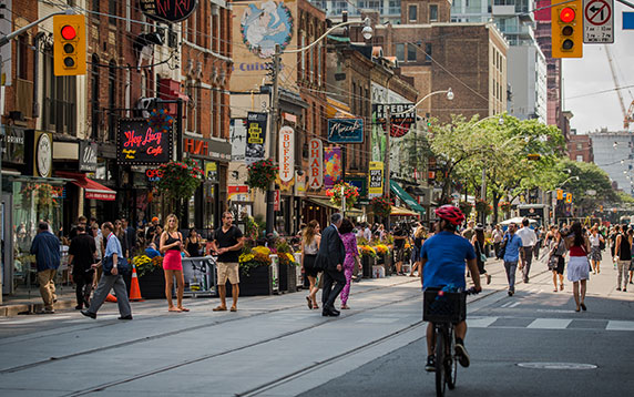 Padestrians crossing a busy Toronto intersection.