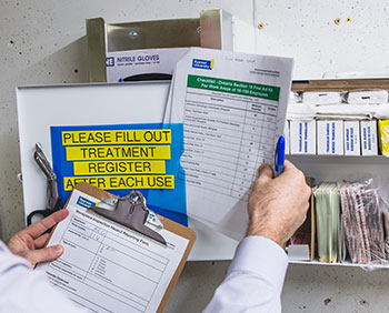 A person reviewing the checklist inside a first aid kit. 