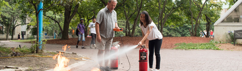 A Ryerson fire warden being trained how to put out a fire at the annual fire extinguisher training.