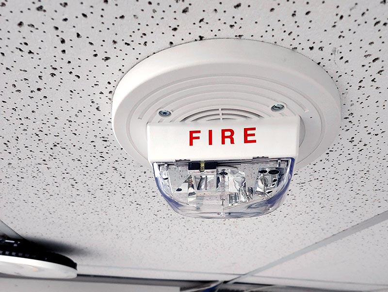 A ceiling-mounted fire alarm strobe light and sounding device