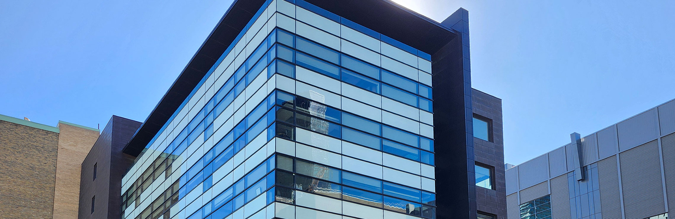 The Chang School building with the sun bursting out from behind it.
