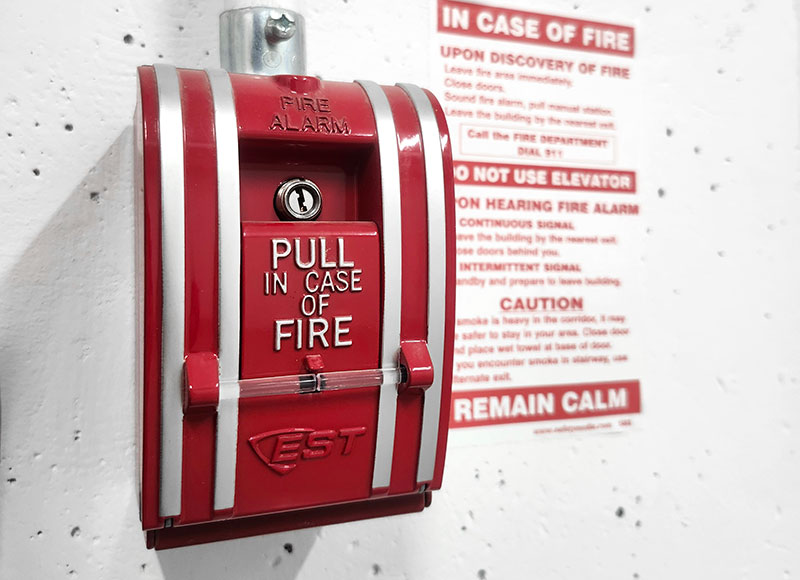 A red pull station which activates an fire alarm when pulled.