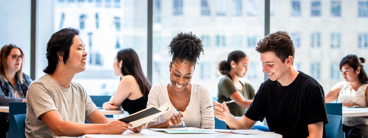 Three students studying indoors on the TMU campus 
