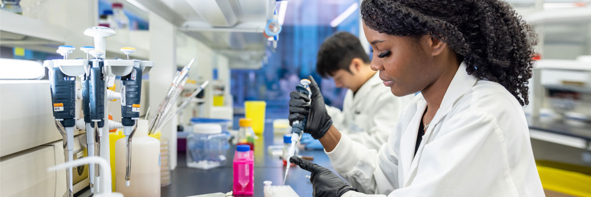 A diverse group of students work in a lab.