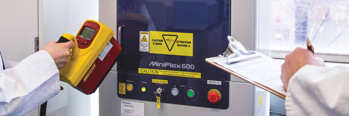 A close-up of a geiger counter checking a machine for radiation safety during safety inspections.