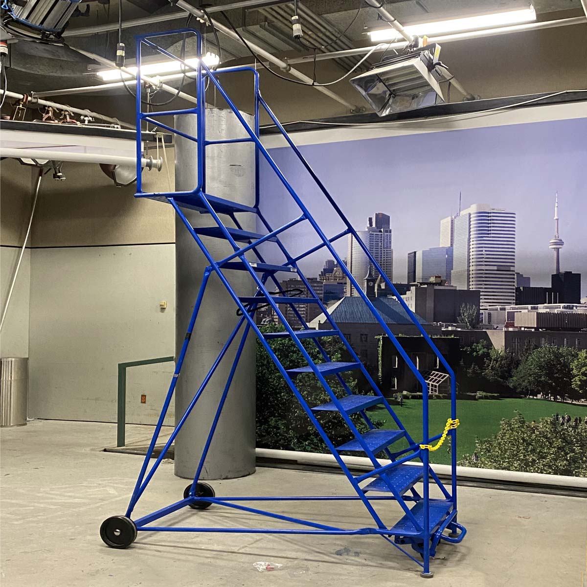 A rolling ladder, which is often seen in warehouses, also provides a platform to reach and adjust studio lighting.