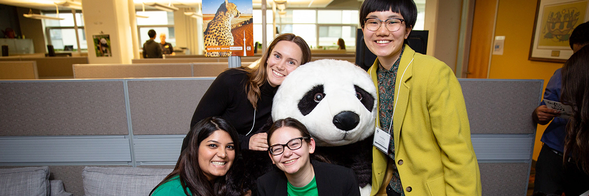 Four Ryerson students hugging the WWF panda mascot.
